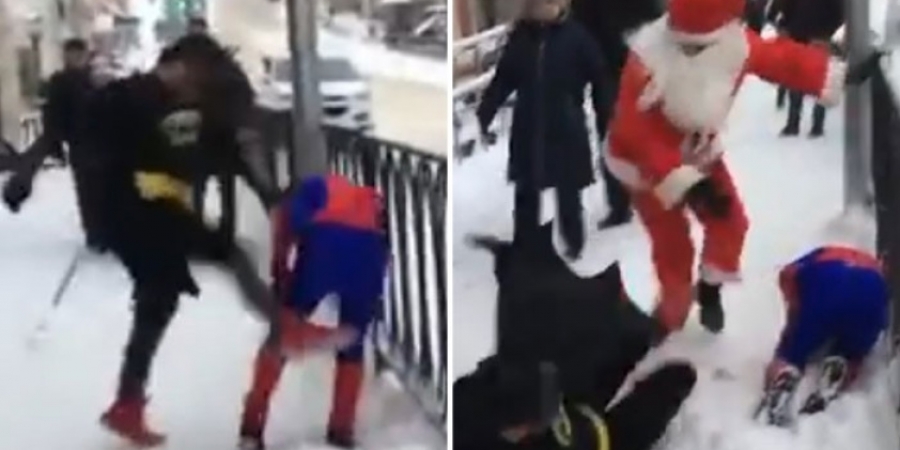 Guy dressed as Batman beats up Spiderman before Santa steps in to save the day