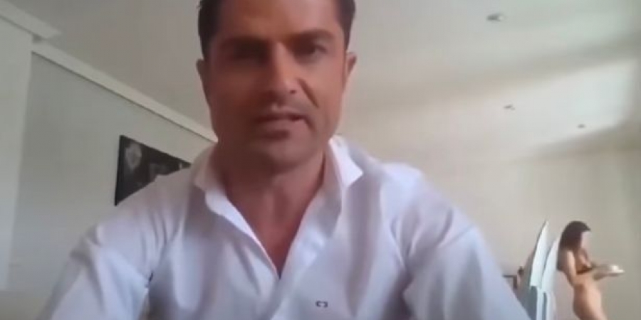 Topless woman walks into shot during journalist's video call